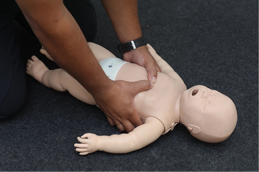 Infant emergency awareness training using a baby CPR mannequin